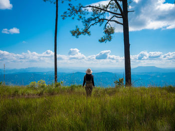 Rear view of woman on field against sky