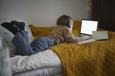 Girl using laptop in her bedroom