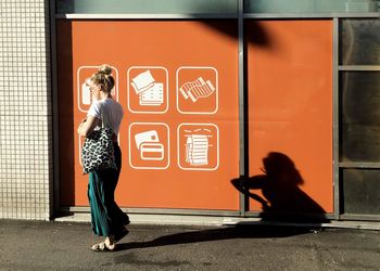 Full length of woman standing against wall