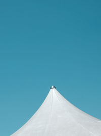 Low angle view of white fabric roof against clear blue sky