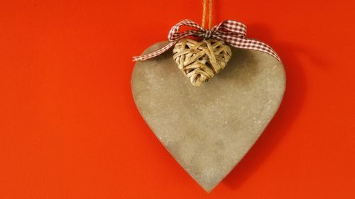 Close-up of heart shape decoration on red background