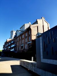 Low angle view of buildings against clear blue sky