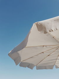 Low angle view of umbrella against clear blue sky