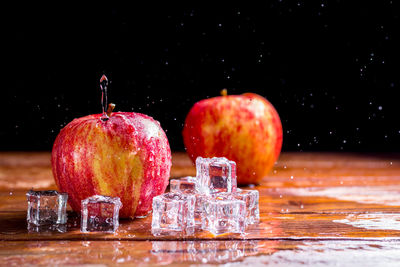 Close-up of apples on table against black background