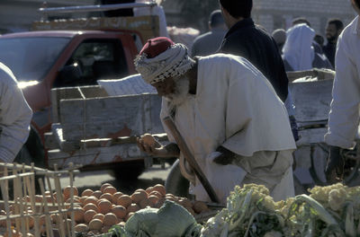 Rear view of men working at market