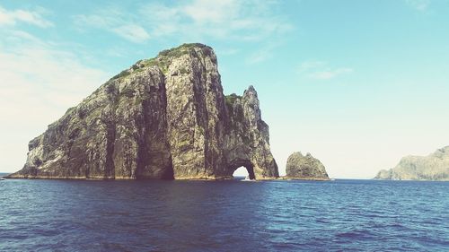 Rock formations by sea against sky