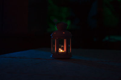 Close-up of illuminated lamp on table