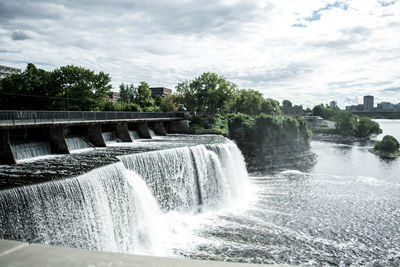 Scenic view of waterfall against sky