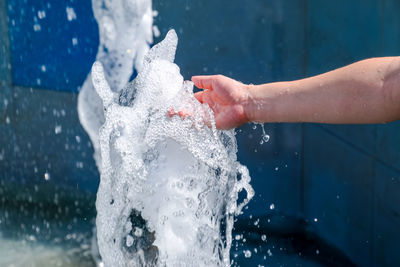Close-up of hands splashing water at poolside