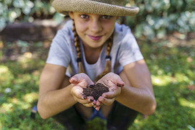 Portrait of happy girl holding plant