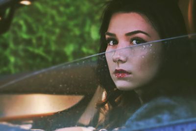 Close-up of young woman in car