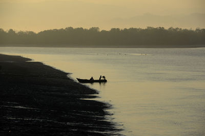 Remote boat leaving at sunset