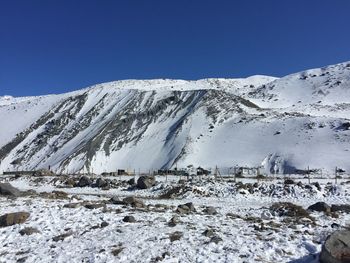 Scenic view of snowcapped mountains against clear blue sky