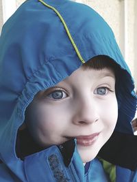 Close-up of cute boy wearing hooded jacket looking away