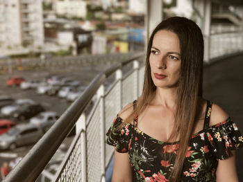 Thoughtful woman standing in balcony