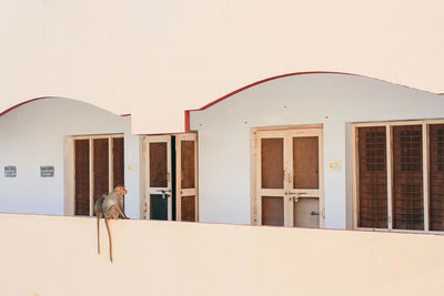 Buildings against sky seen through window