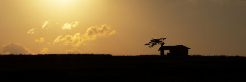 Scenic view of silhouette field against sky during sunset