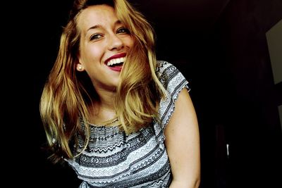 Portrait of young woman against black background