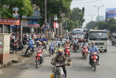 People riding bicycle on road in city