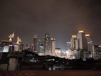 Illuminated buildings in city against sky at night