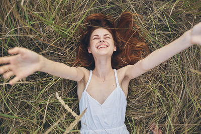 Portrait of smiling young woman standing on field