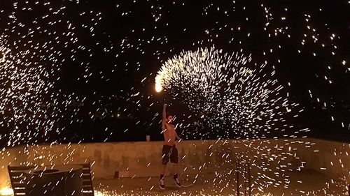 Low angle view of firework display at night