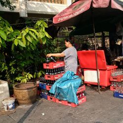 Rear view of woman sitting on wall