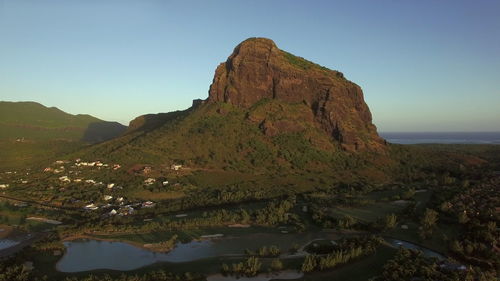 Scenic view of sea and mountains against clear sky