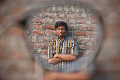 Portrait of young man seen through eyeglasses