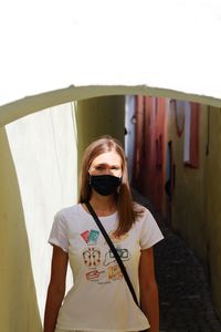 Portrait of young woman with coronavirus mask on the street