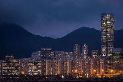 Illuminated buildings in city against sky at night