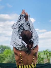 Rear view of woman standing against sky