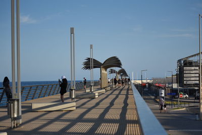 People at observation point against sky in city
