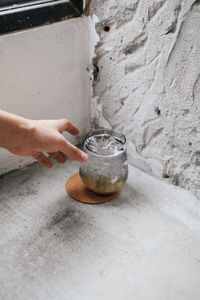 Close-up of hand holding drink on table