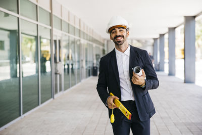 Young man wearing hat standing against wall