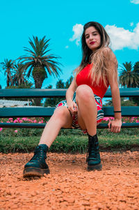 Young woman sitting on palm tree