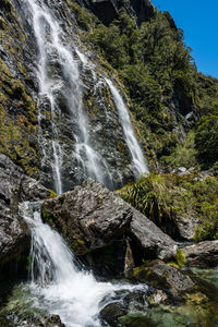 Scenic view of earland falls waterfall in routeburn forest