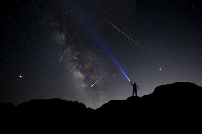 Low angle view of silhouette mountain against sky at night