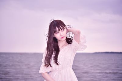 Beautiful woman standing in sea against sky