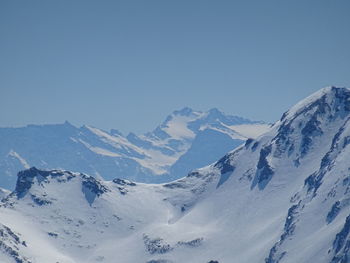 Scenic view of snowcapped mountains against clear blue sky