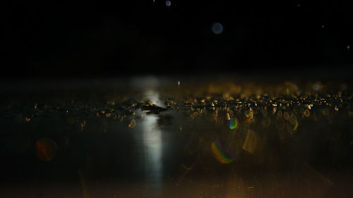 Reflection of illuminated lights on water in city at night