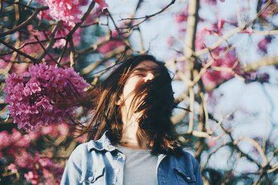 Portrait of woman with red flowers on tree