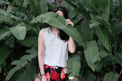 Midsection of woman standing by plants