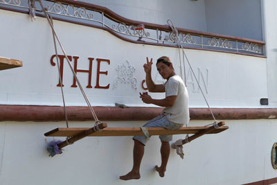 Full length of young man against white wall