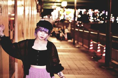 Portrait of woman standing in city at night