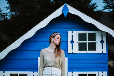 Portrait of woman standing against building