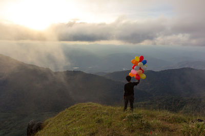 Man standing on mountain against sky