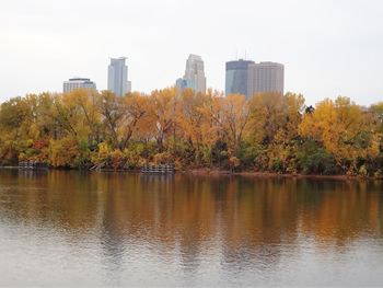Trees and cityscape against sky during autumn