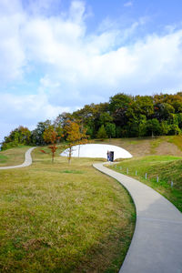 Park on field by road against sky