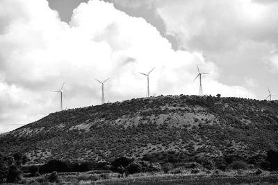 Windmills on a hill ridge in the lake, celestial in the background